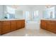 Elegant bathroom with double vanities, soaking tub, and tiled floors at 1500 Ember Ln, Tarpon Springs, FL 34689