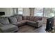 Spacious living room with L-shaped sofa and wood-look floors at 1153 Tamarac Dr, Holiday, FL 34690