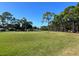 Scenic view of lush golf course with mature trees, green fairways, and golfers at 8551 Electra Ave, Brooksville, FL 34613