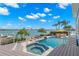 Beautiful backyard featuring a pool, hot tub, and lounge area with stunning water views at 295 Bayside Dr, Clearwater Beach, FL 33767