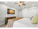 Bright bedroom featuring a ceiling fan, TV, a wooden dresser, and closet doors at 295 Bayside Dr, Clearwater Beach, FL 33767