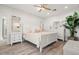 Neutral bedroom with light wood floors, a ceiling fan, and white furnishings at 295 Bayside Dr, Clearwater Beach, FL 33767