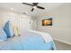 Bedroom featuring a ceiling fan, TV, closet doors, and neutral decor at 295 Bayside Dr, Clearwater Beach, FL 33767