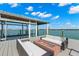 View of a boat dock with lounge seating and a firepit with beautiful waterfront views at 295 Bayside Dr, Clearwater Beach, FL 33767