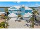 Beautiful blue coastal home with a metal roof, three-car garage and lush landscaping at 295 Bayside Dr, Clearwater Beach, FL 33767