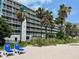 Hotel building and beach with lounge chairs, offering a relaxing beachfront view at 5500 Gulf Blvd # 7211, St Pete Beach, FL 33706