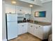 Compact kitchenette with white cabinets and modern appliances at 5500 Gulf Blvd # 7211, St Pete Beach, FL 33706