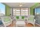 Relaxing screened porch with white wicker furniture at 105 Island Way # 121, Clearwater Beach, FL 33767