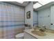 Cozy bathroom with shower, tub, white vanity, and blue striped shower curtain at 403 Gulf Way # 504, St Pete Beach, FL 33706