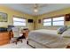 Comfortable bedroom featuring bright walls, tiled floor, desk, and a ceiling fan at 403 Gulf Way # 504, St Pete Beach, FL 33706