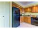 Compact kitchen features a black refrigerator and wood cabinets at 403 Gulf Way # 504, St Pete Beach, FL 33706