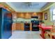 Functional kitchen features tile floor, wood cabinets and black appliances at 403 Gulf Way # 504, St Pete Beach, FL 33706
