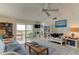 Bright living room featuring tile flooring, ceiling fan, access to balcony with ocean views, and lots of bookshelves at 403 Gulf Way # 504, St Pete Beach, FL 33706