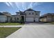 Two-story house with gray siding, stone accents, and a three-car garage at 12821 Bergstrom Bay Dr, Riverview, FL 33579