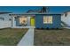 Modern house exterior at night with lime green door and small porch at 5334 37Th N St, St Petersburg, FL 33714