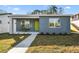 Modern house with gray siding, lime green door, and small front porch at 5334 37Th N St, St Petersburg, FL 33714