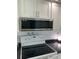 Modern kitchen with stainless steel microwave and electric cooktop at 2101 Sunset Point Rd # 1302, Clearwater, FL 33765