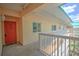 Condo hallway with orange door and white railing at 18400 E Gulf Blvd # Ph-11, Indian Shores, FL 33785