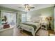 Bright bedroom with a queen-size bed, wood-look floors, and sliding door access to a patio at 103 Cypress Pond Rd # 103, Palm Harbor, FL 34683