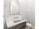 Elegant powder room with dark vanity, marble sink, and arched mirror at 266 8Th N Ave, Tierra Verde, FL 33715