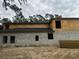 Side view of a two-story house under construction, showcasing a modern design and large windows at 8418 Fussell Dr, Wesley Chapel, FL 33545