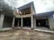 Rear view of a two story house under construction, featuring a modern design and covered patio at 8418 Fussell Dr, Wesley Chapel, FL 33545