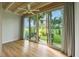 Bright bedroom with wood floors and sliding glass doors leading to the patio at 6302 Pelican Creek Xing # A, St Petersburg, FL 33707