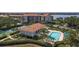 Aerial view of the community with a pool, tennis courts and clubhouse nestled in mature trees overlooking the waterfront at 1806 Mariner Dr # 214, Tarpon Springs, FL 34689