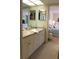 Bathroom featuring a double vanity with mirror, and doorway view into primary bedroom at 1806 Mariner Dr # 214, Tarpon Springs, FL 34689