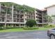 Multi-story condo building exterior with tropical landscaping and exterior balconies at 1806 Mariner Dr # 214, Tarpon Springs, FL 34689