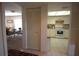 Hallway view of kitchen, dining room, and closet space with tile and carpet flooring at 1806 Mariner Dr # 214, Tarpon Springs, FL 34689