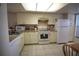 Bright kitchen with tile floors, white appliances, and ample counter space at 1806 Mariner Dr # 214, Tarpon Springs, FL 34689