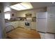 Kitchen featuring white appliances, tile flooring and an adjacent breakfast table at 1806 Mariner Dr # 214, Tarpon Springs, FL 34689