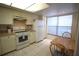 Cozy kitchen with tile flooring, white cabinets, and a breakfast nook area at 1806 Mariner Dr # 214, Tarpon Springs, FL 34689