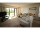 Comfortable living room area with a sofa, natural light, and balcony access at 1806 Mariner Dr # 214, Tarpon Springs, FL 34689