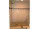 Walk-in shower with tile surround, built-in shelving, shower head, and mosaic accents at 1806 Mariner Dr # 214, Tarpon Springs, FL 34689