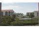 Balcony view showcasing a pond, mature landscaping, and surrounding buildings at 1806 Mariner Dr # 214, Tarpon Springs, FL 34689