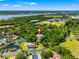 Aerial view showing home's location in a lush, green community with a pool and tennis courts at 9660 90Th Ave, Seminole, FL 33777