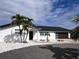 Modern single-story home with white exterior, dark roof, and landscaped yard at 240 N Julia Cir, St Pete Beach, FL 33706