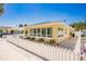 Cute yellow house with white picket fence, large windows, and metal roof at 108 11Th Ave, St Pete Beach, FL 33706