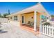 Front exterior view with covered porch and white picket fence at 108 11Th Ave, St Pete Beach, FL 33706