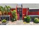 Exterior shot of the red brick apartment complex with stairs, greenery and updated paint at 8221 12Th N Way # F, St Petersburg, FL 33702