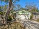 Home with a two car garage, light exterior paint, green trim, and nice landscaping at 679 Lake Maggiore S Blvd, St Petersburg, FL 33705
