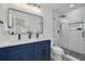 Modern bathroom with blue vanity, dual sinks, and a walk-in shower at 7414 Van Dyke Rd, Odessa, FL 33556