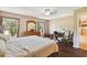 Main bedroom with large bed, desk, and backyard view at 18602 Bent Pine Dr, Hudson, FL 34667