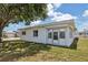 Single story home with white exterior, roll-down shutters, and large tree at 5396 Acacia N Trl, Pinellas Park, FL 33782