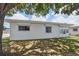 Single story home with white exterior, roll-down shutters, and large tree at 5396 Acacia N Trl, Pinellas Park, FL 33782