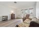 Living room with floral sofa and recliner, wood floors at 5396 Acacia N Trl, Pinellas Park, FL 33782