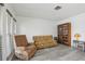 Living room with floral sofa and recliner, wood floors at 5396 Acacia N Trl, Pinellas Park, FL 33782