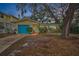 House exterior at dusk, teal garage door, and mature trees at 335 Tucker St, Safety Harbor, FL 34695